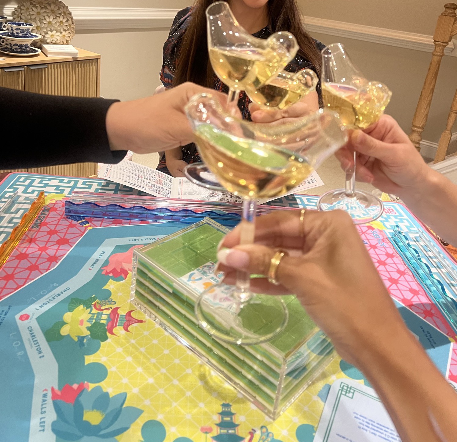 A toast with bird-shaped glasses over a set mahjong table